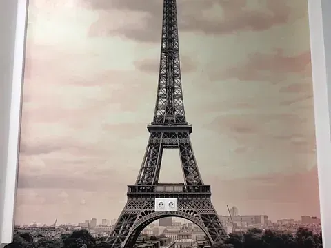 Torre Eiffel en París, Francia, con un cielo nublado en tonos sepia y un paisaje urbano de fondo.
