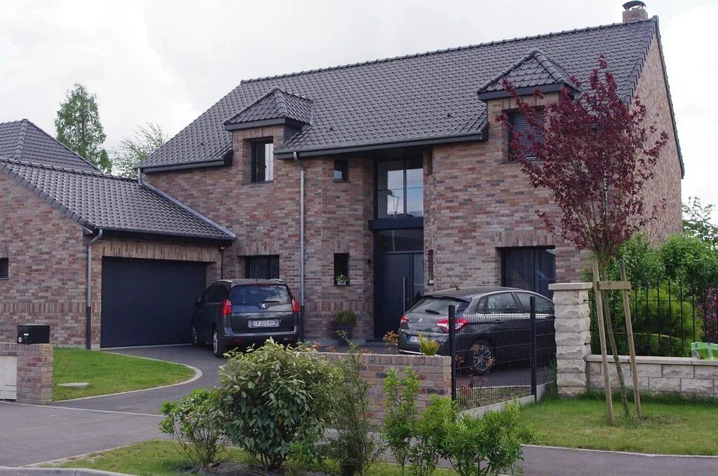Maison contemporaine avec garage et deux voitures garées devant