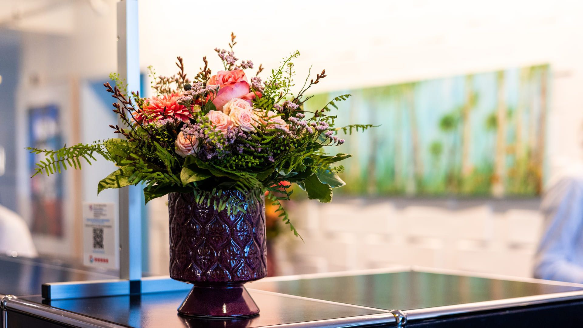 Auf einem Tisch steht eine Vase voller Blumen.