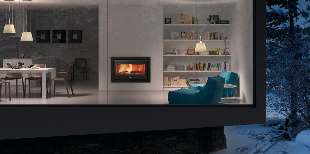 Una sala de estar con chimenea y un comedor con mesa y sillas.