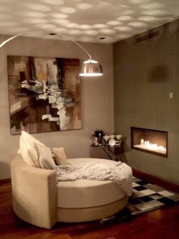 Una sala de estar con un sofá redondo y una chimenea.