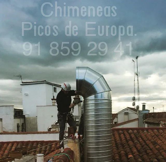 Un hombre está trabajando en una chimenea en el tejado de un edificio.