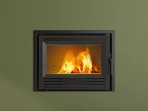 Una chimenea con llamas saliendo de ella está colgada en una pared verde.