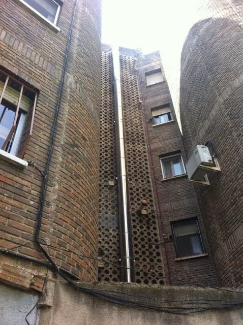 Un edificio de ladrillo con una chimenea en el costado.