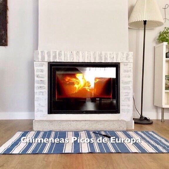 Una sala de estar con chimenea y una alfombra que dice 