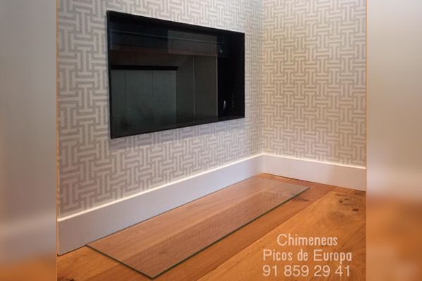 Una sala de estar con un televisor de pantalla plana montado en la pared.