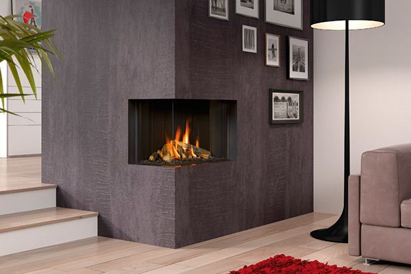 Una sala de estar con chimenea, sofá, lámpara y cuadros en la pared.