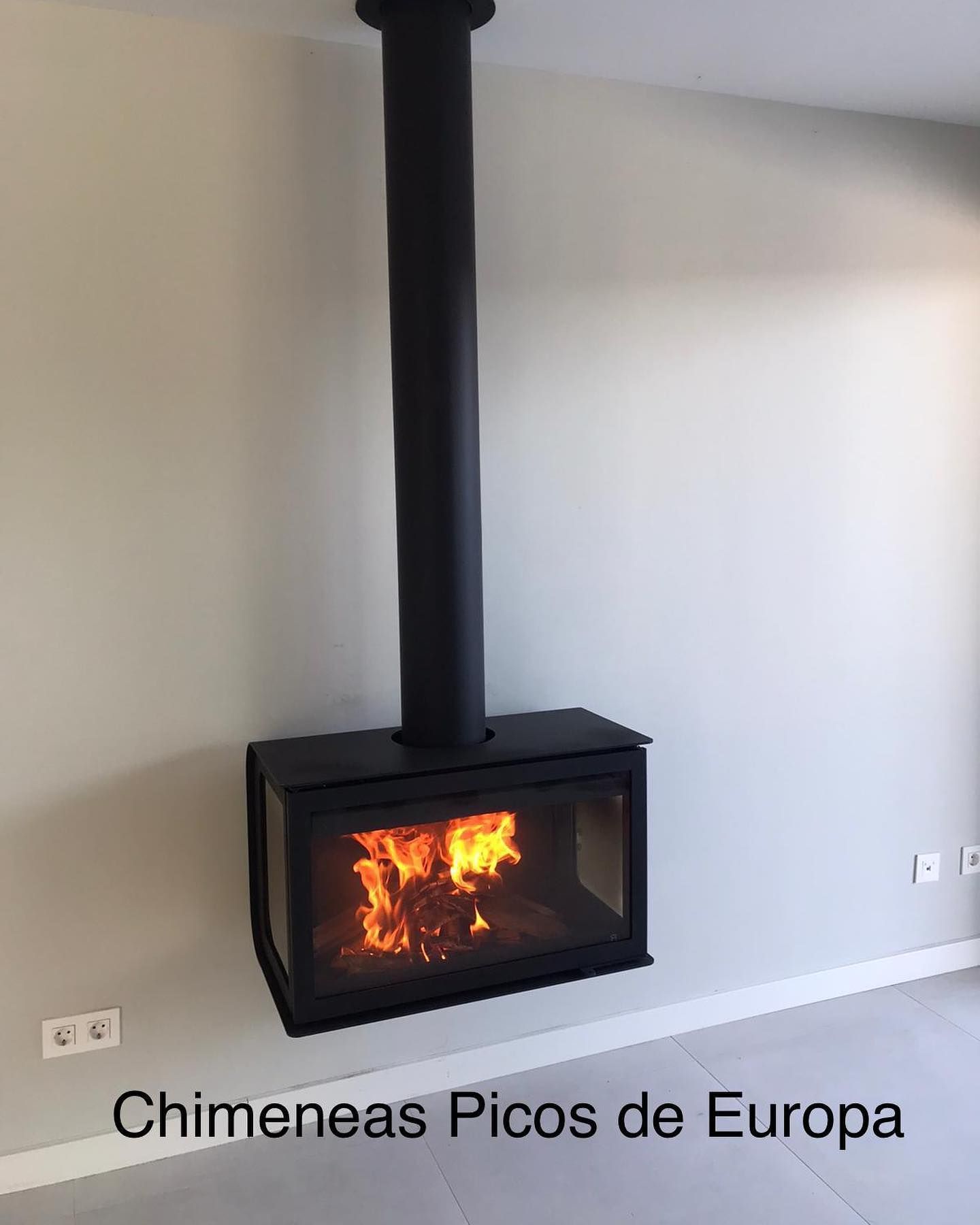 Una chimenea cuelga del techo en una sala de estar.