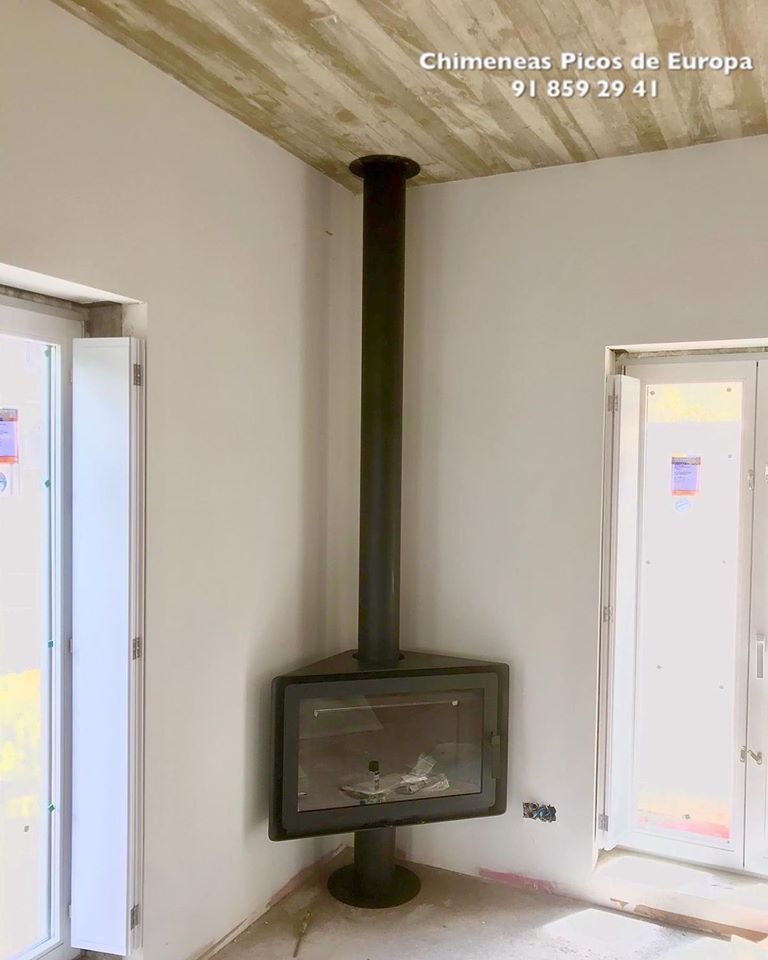 Una habitación con una chimenea en la esquina.