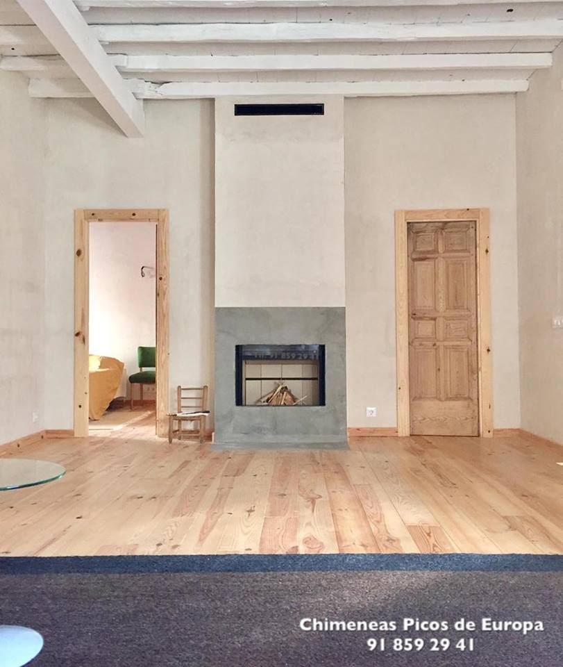 Una sala de estar con chimenea y un número de teléfono 91 859 29 41