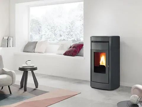 Una sala de estar con estufa y un asiento junto a la ventana.