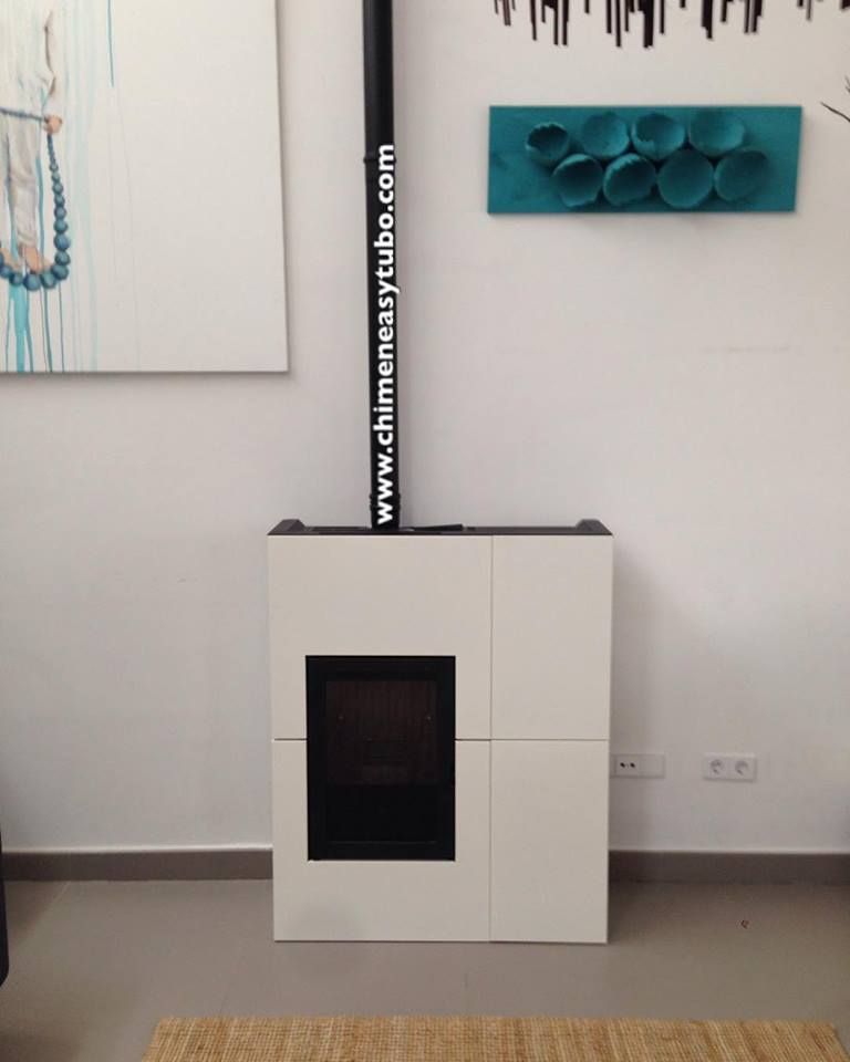 Una chimenea blanca en una sala de estar con una pintura en la pared encima.