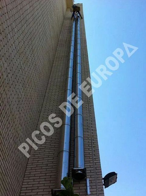 Un edificio de ladrillo con una tubería de acero inoxidable en el costado.