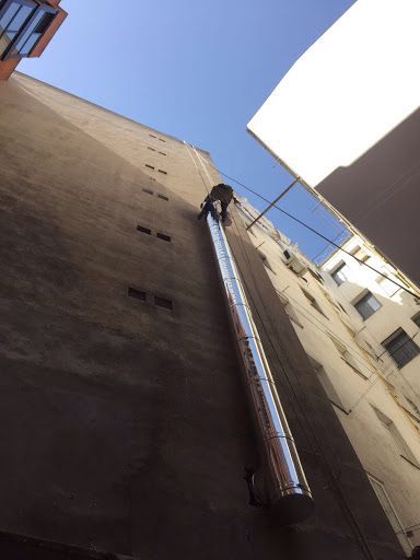 Un hombre está subiendo por el costado de un edificio.
