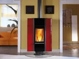 Una estufa roja está en una sala de estar al lado de un sofá.