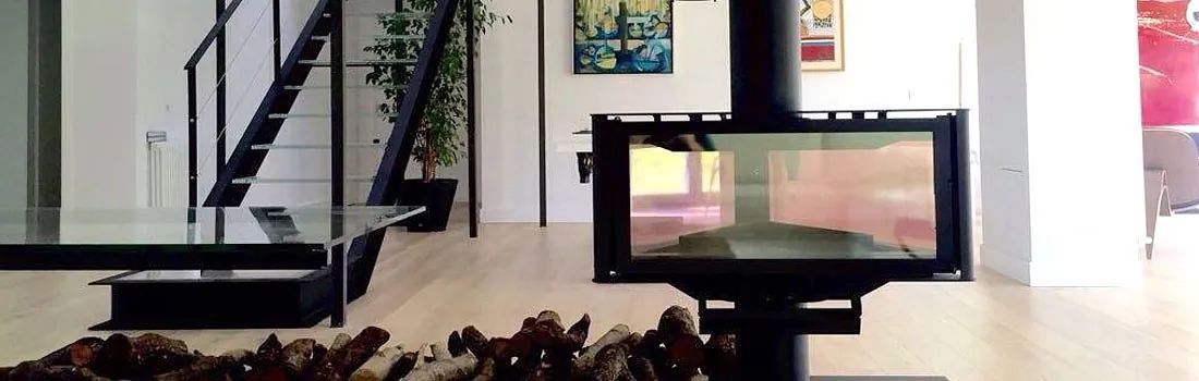Una sala de estar con chimenea y escaleras al fondo.