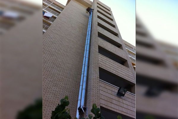 Un edificio alto con una tubería muy larga en el costado.