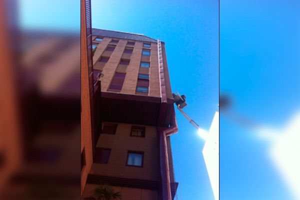 Mirando hacia arriba a un edificio alto con un cielo azul en el fondo