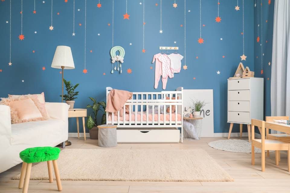 Ein Babyzimmer mit Kinderbett, Couch, Tisch und Stühlen.