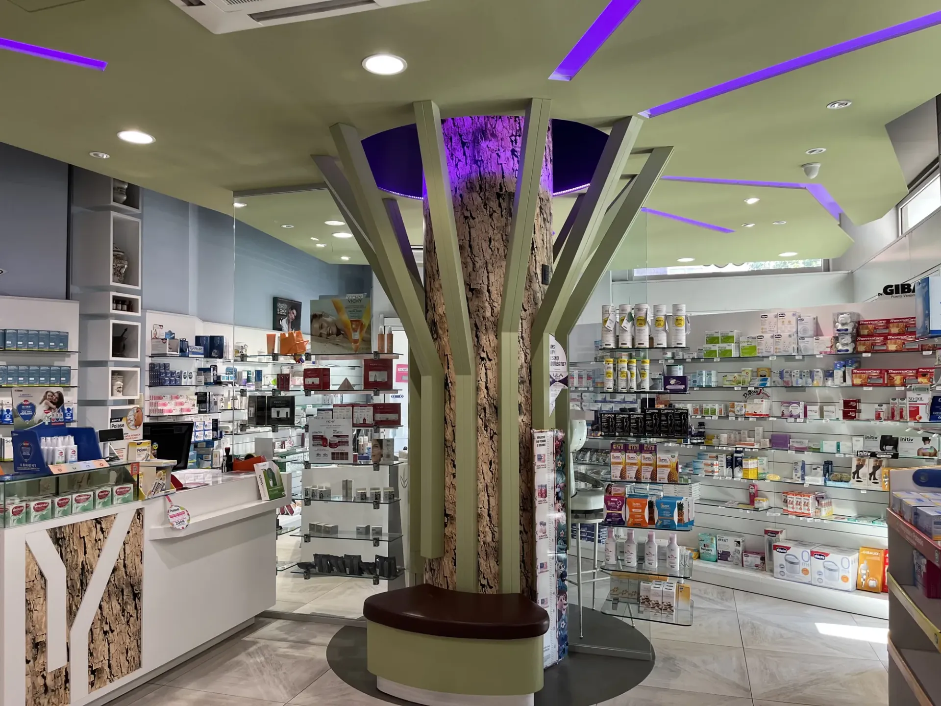 Interno della farmacia San Rocco con un albero stilizzato in legno