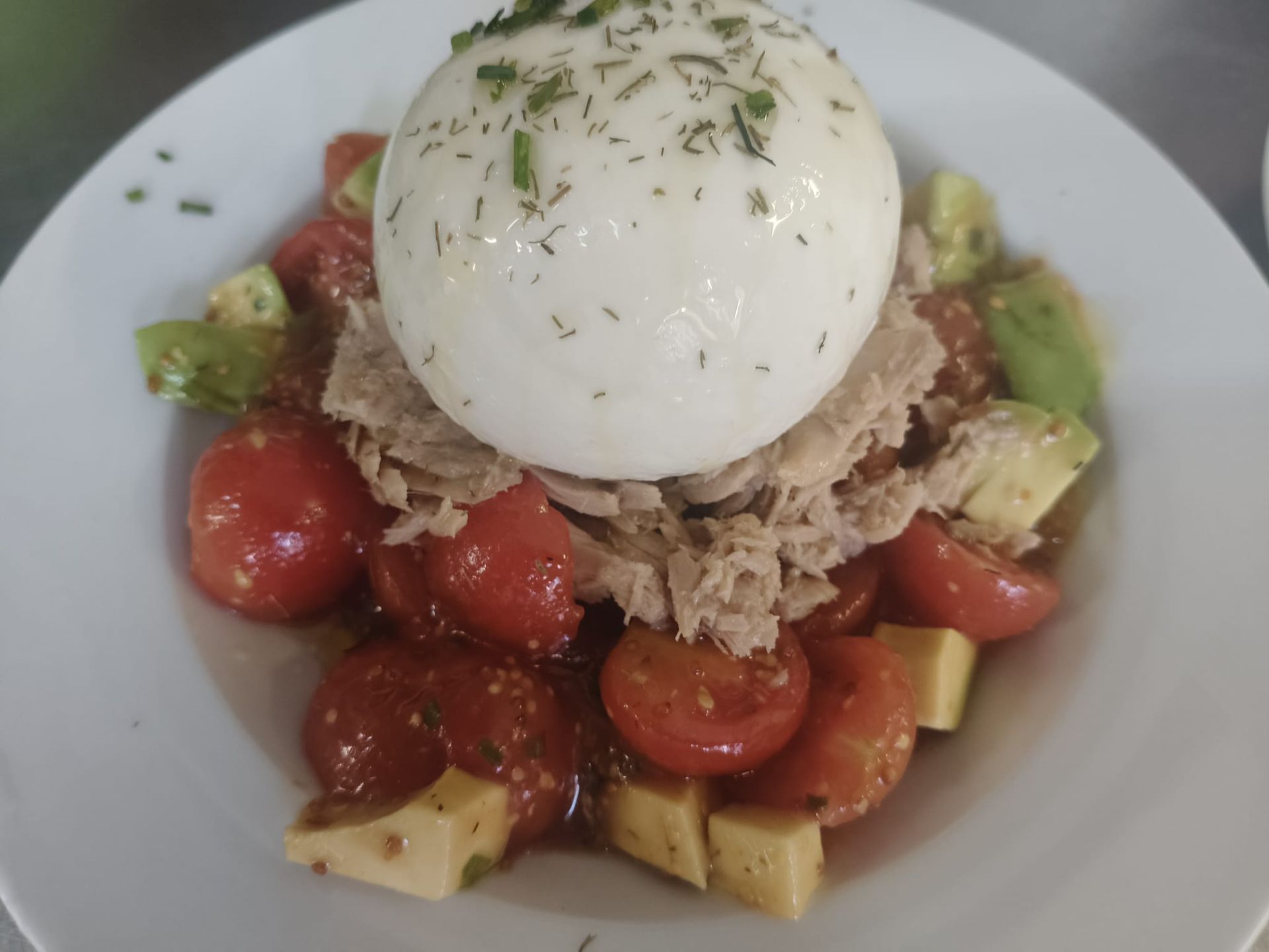 Costillas a la parrilla con patatas fritas y pimiento asado en un plato blanco.