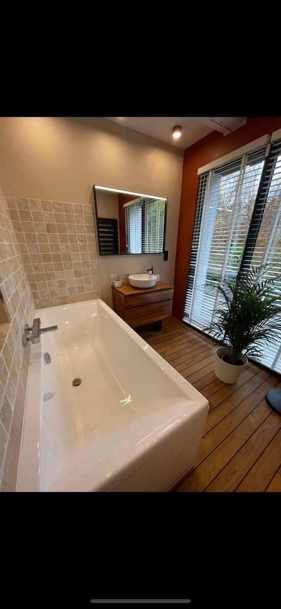 Baignoire, meuble vasque et plante verte