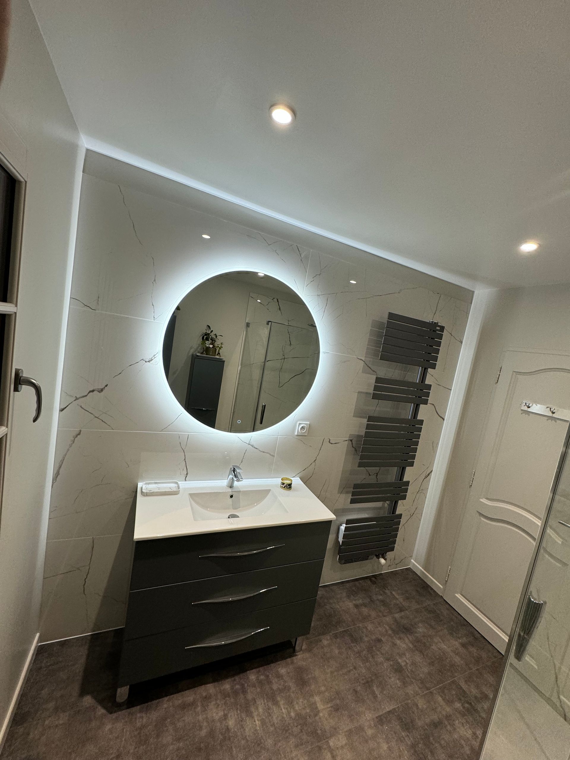 Rénovation salle de bains avec lumière néon sur miroir