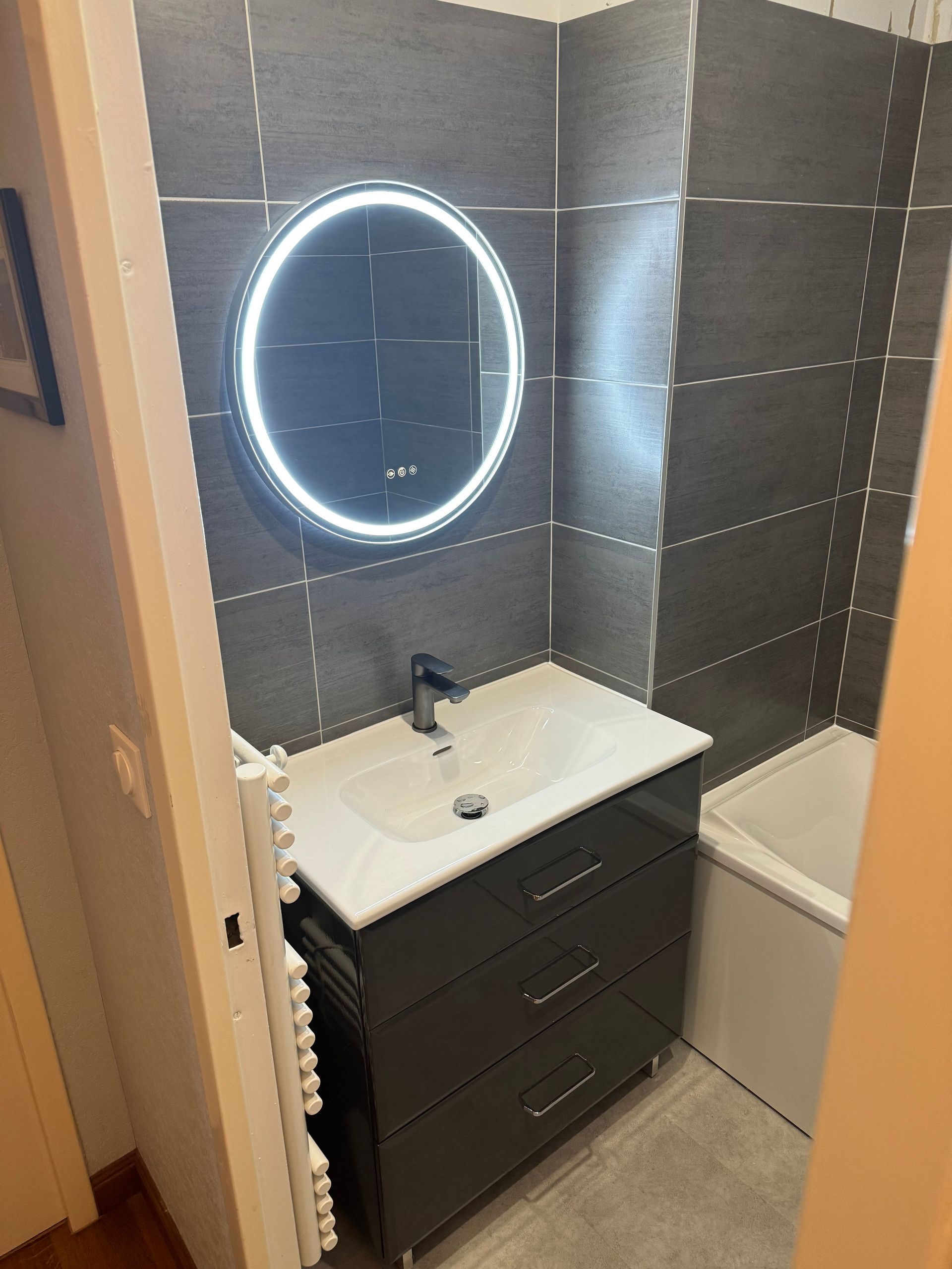 Lumière néon sur miroir ovale dans une salle de bains