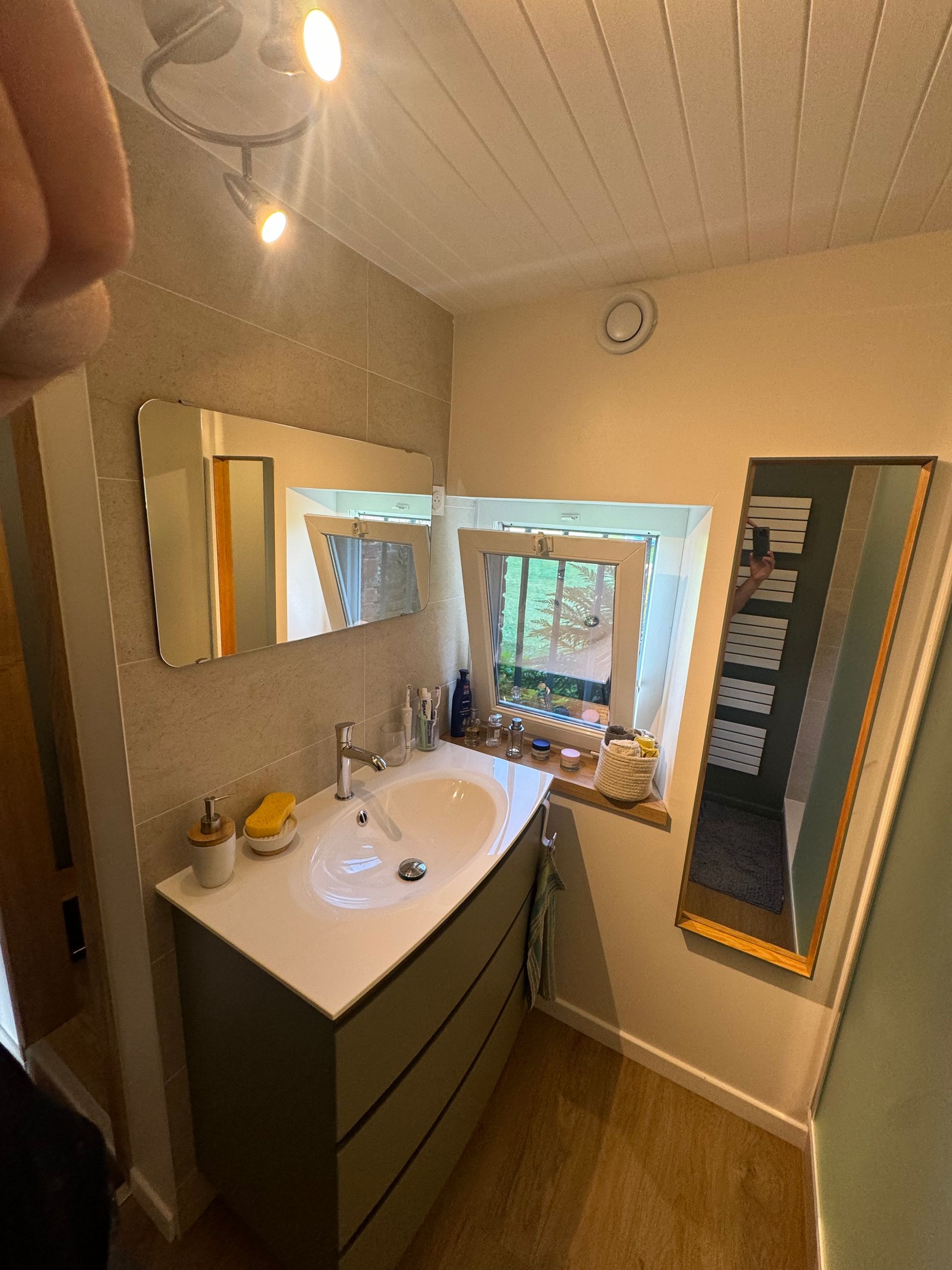 Rénovation salle de bains avec miroir rectangulaire et meubles de rangement avec une vasque