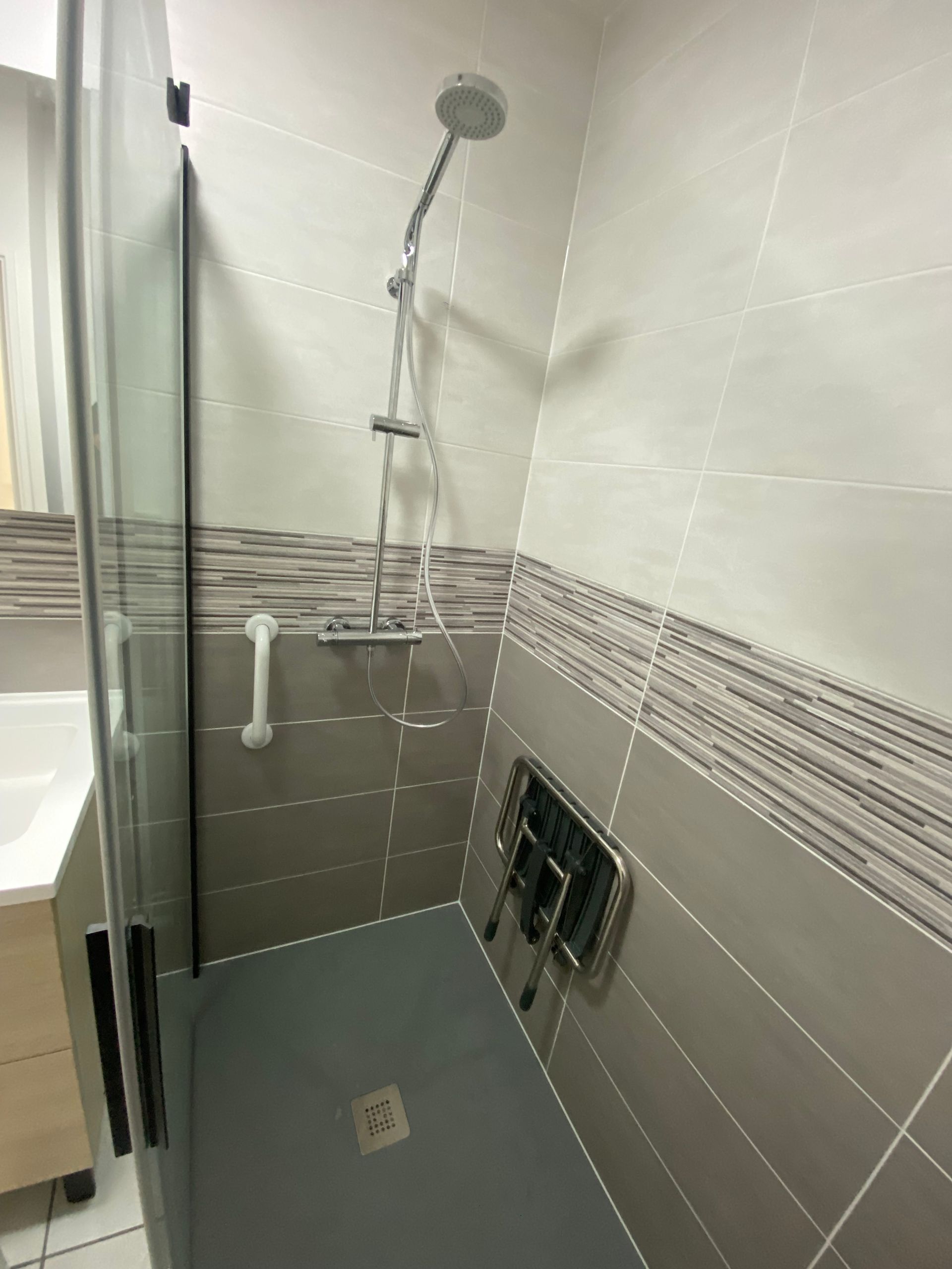 Cabine de douche avec une rampe pour les personnes à mobilité réduite (PMR)