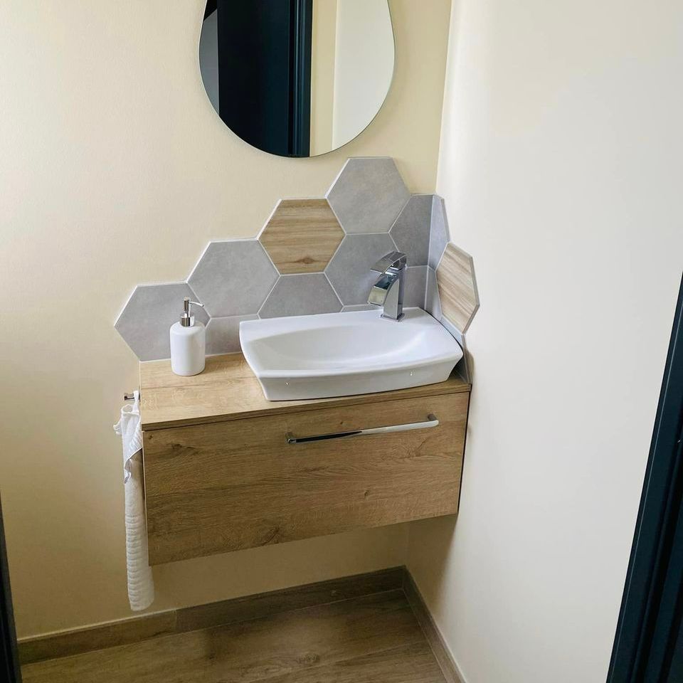 Lave-mains, meuble en bois et miroir avec un carrelage rétro