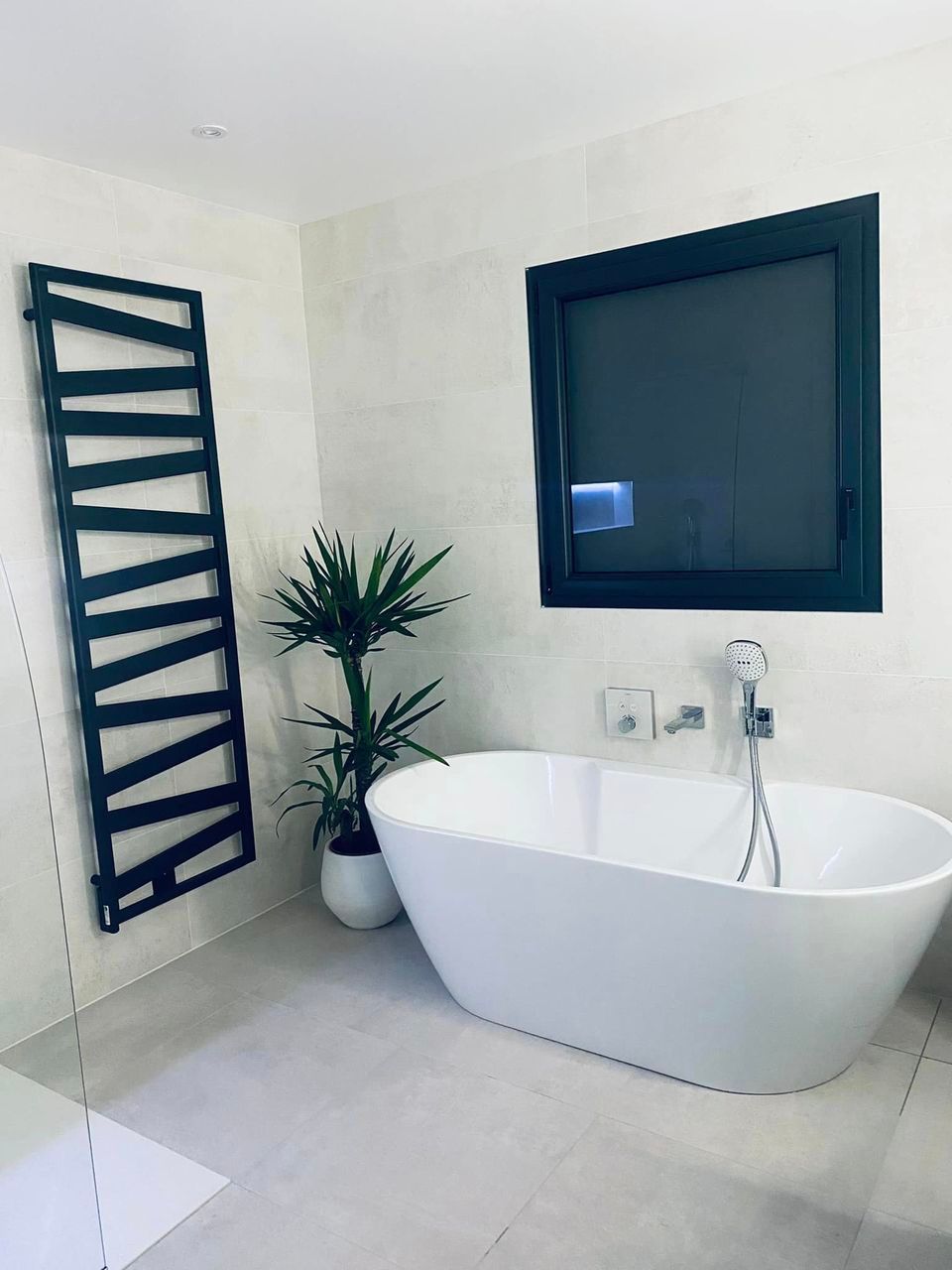 Salle de bains design avec niche, sèche-serviettes noir, baignoire