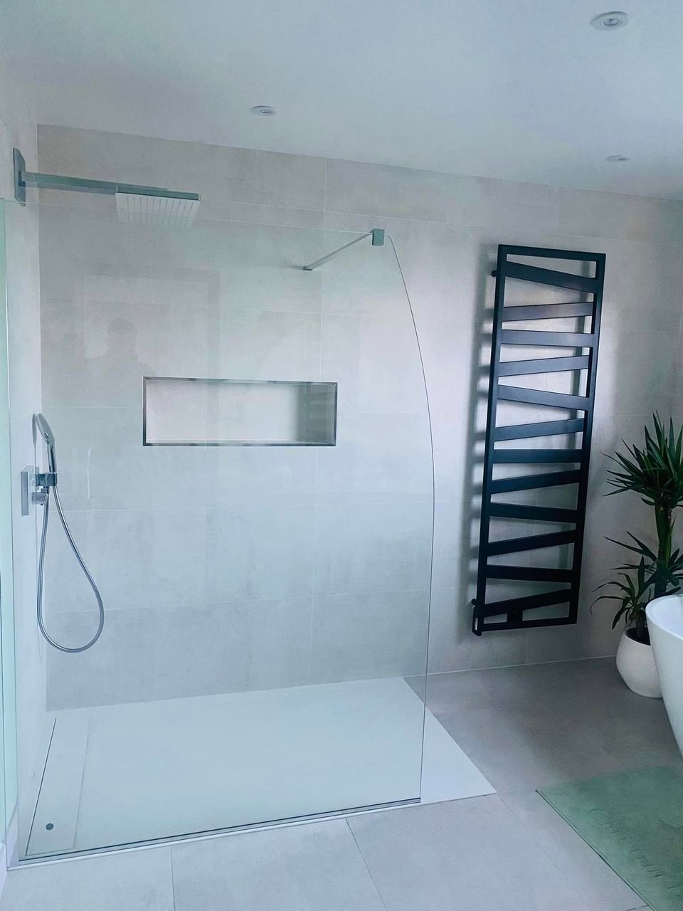 Salle de bains design avec niche, sèche-serviettes noir, douche