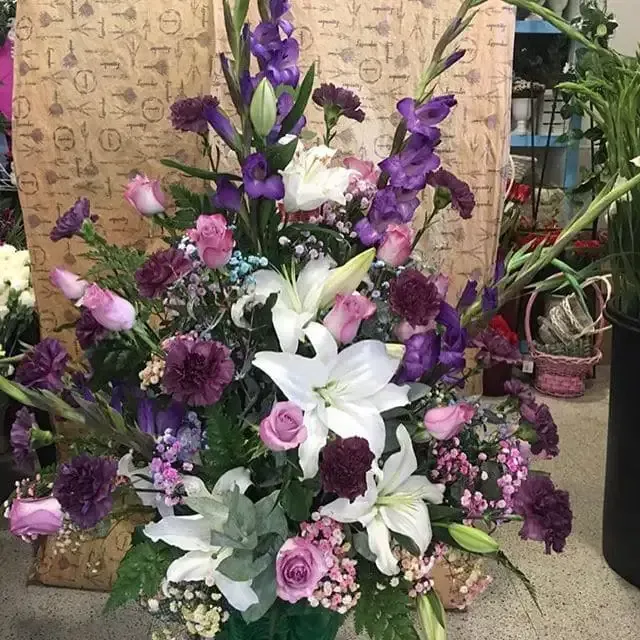 Un ramo de flores moradas y blancas en un jarrón.