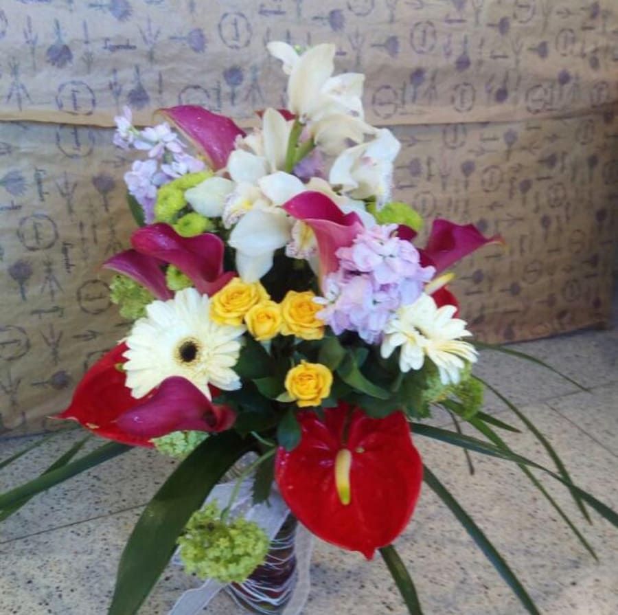 Un ramo de flores con una flor roja en el medio.