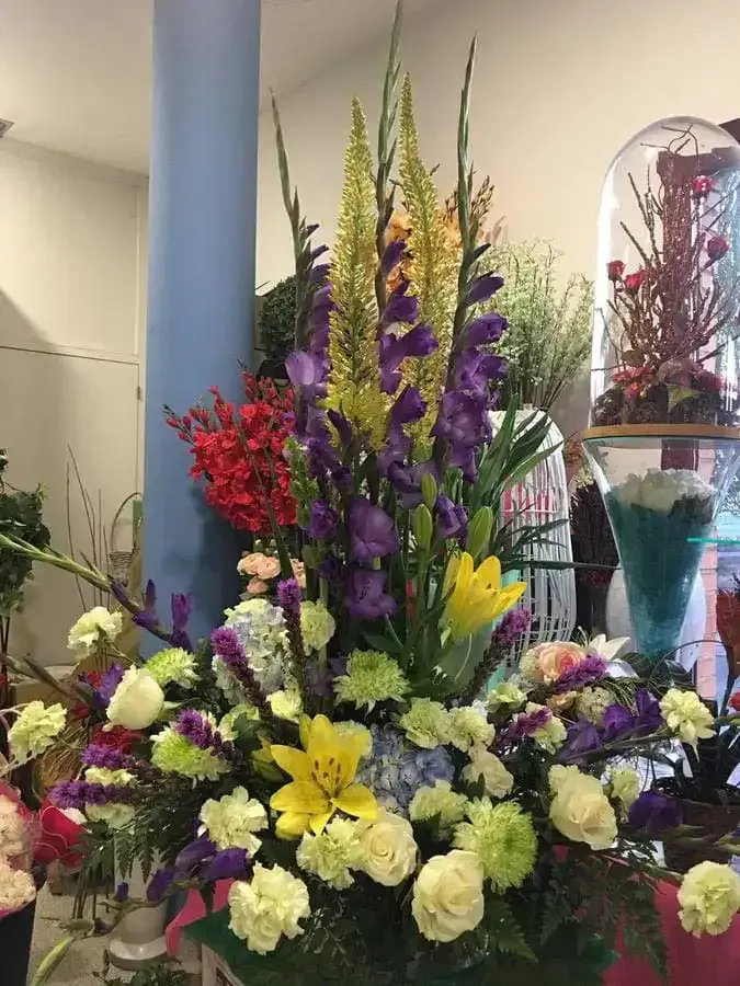 Un gran ramo de flores está sobre una mesa en una habitación.