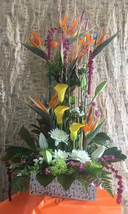 Un gran ramo de flores está sobre una mesa.