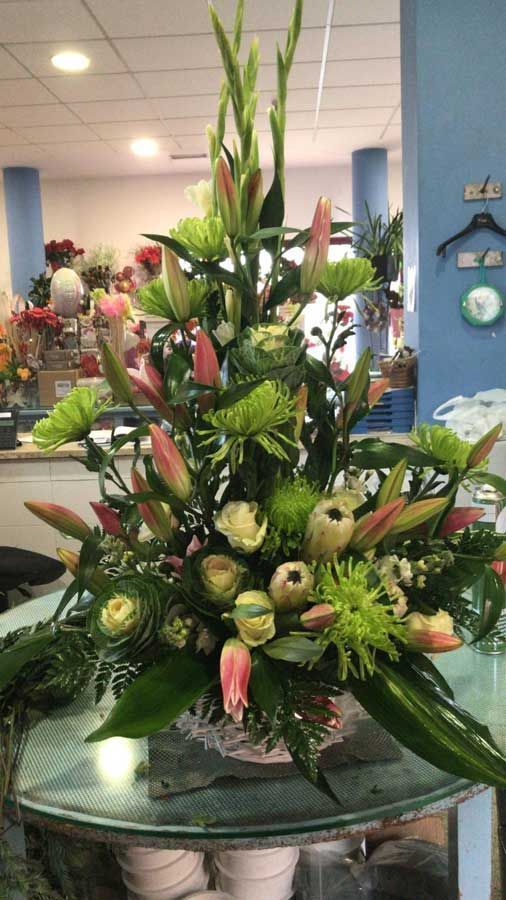 Un gran ramo de flores está sobre una mesa en una tienda.