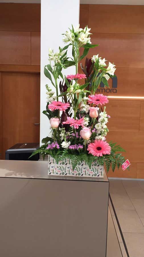 Un ramo de flores rosas y blancas está sobre un mostrador.