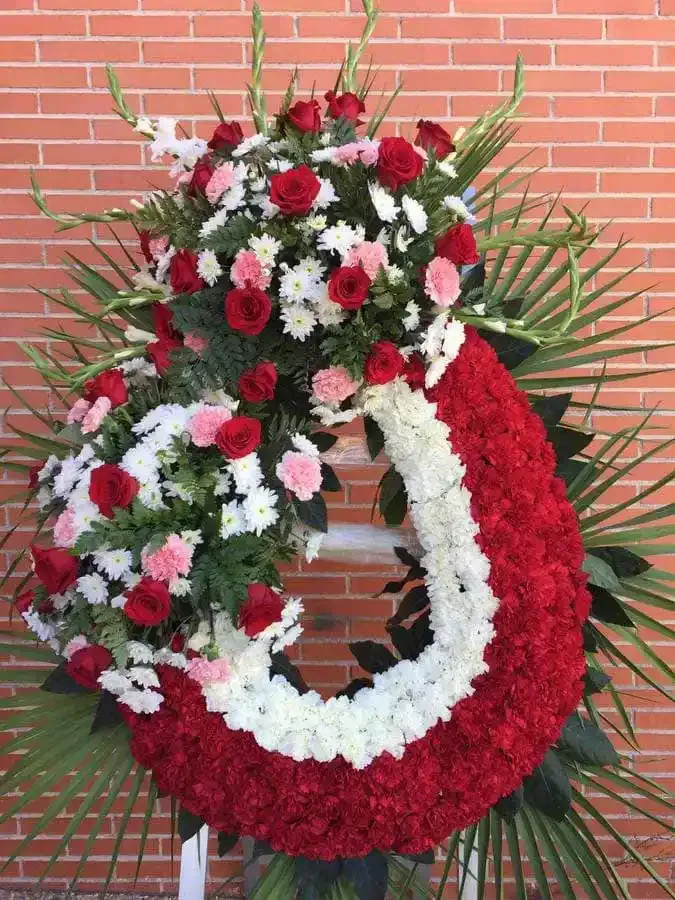 Una corona roja y blanca está delante de una pared de ladrillos.