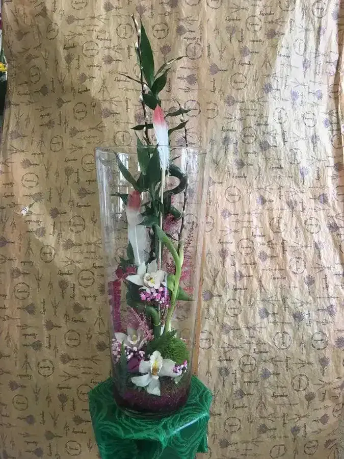 Un jarrón lleno de flores está sobre una mesa.