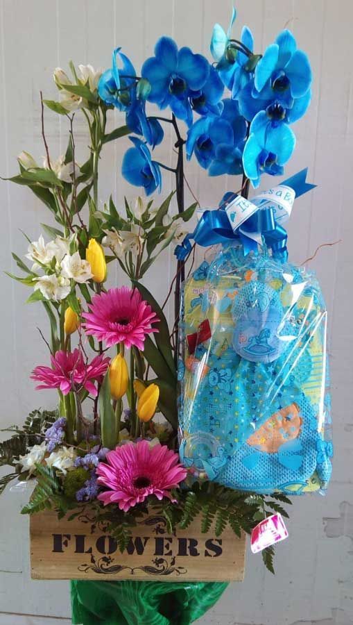 Una caja de madera llena de flores y una bolsa de pañales.