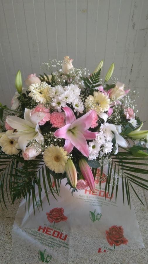 Un gran ramo de flores está sobre una mesa.