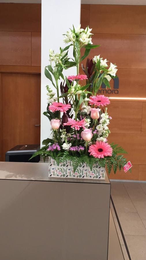 Un ramo de flores rosas y blancas está sobre un mostrador.