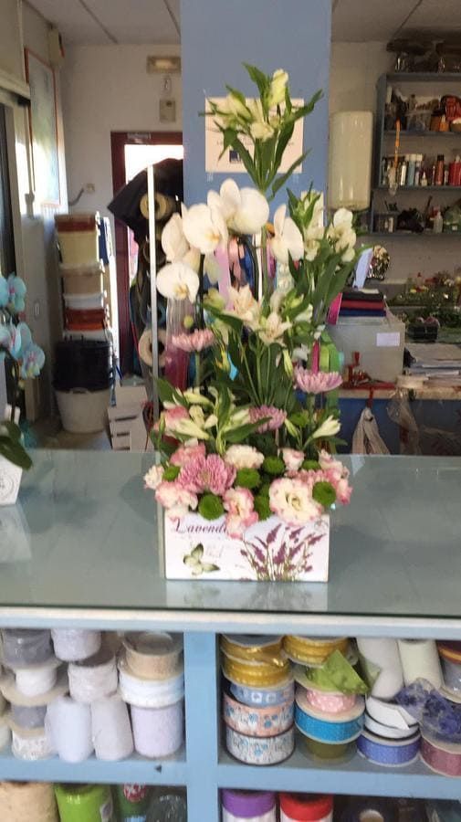 Un jarrón de flores reposa sobre un mostrador en una tienda.