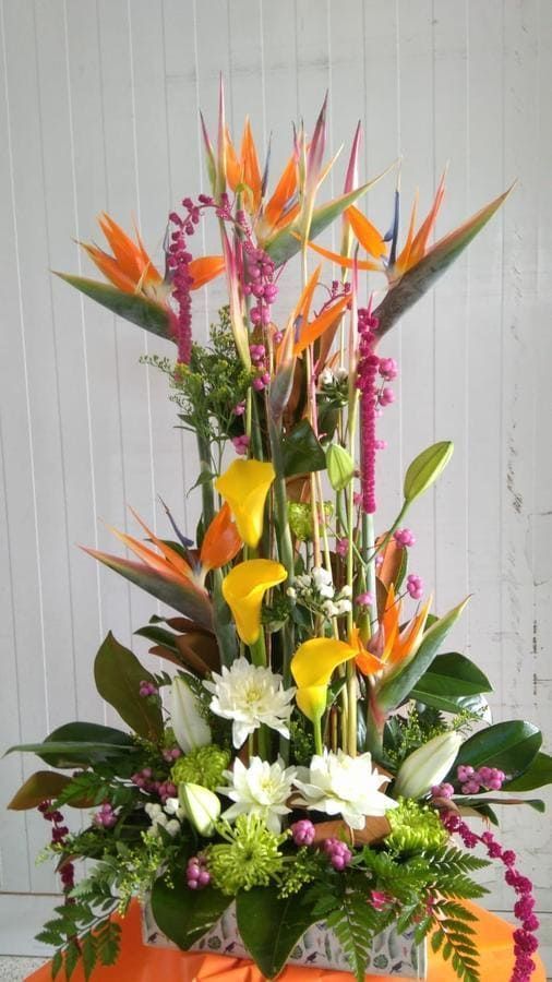 Un gran ramo de flores está sobre una mesa.