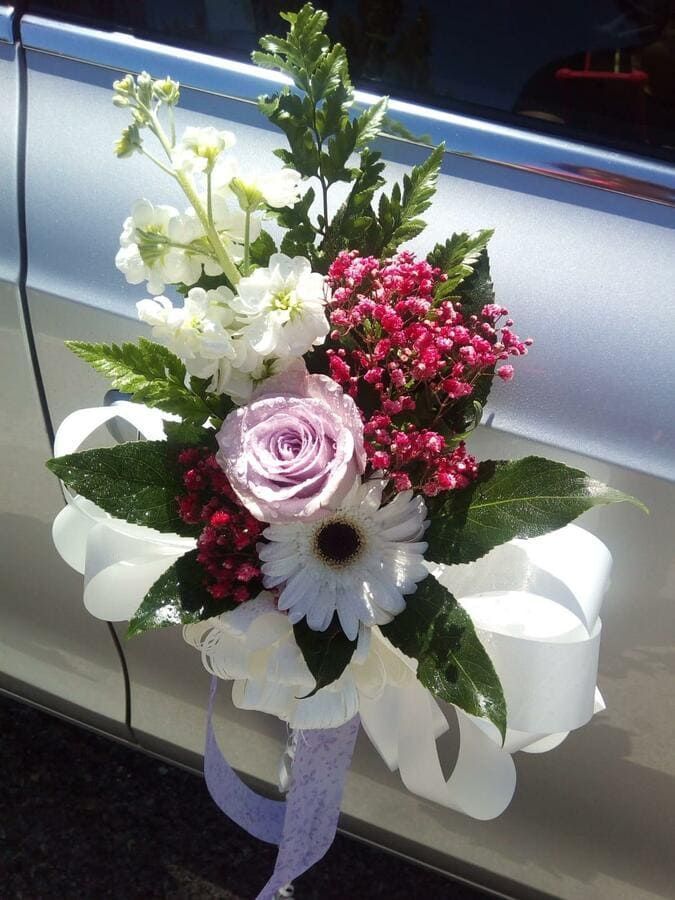 Un ramo de flores en el costado de un coche.
