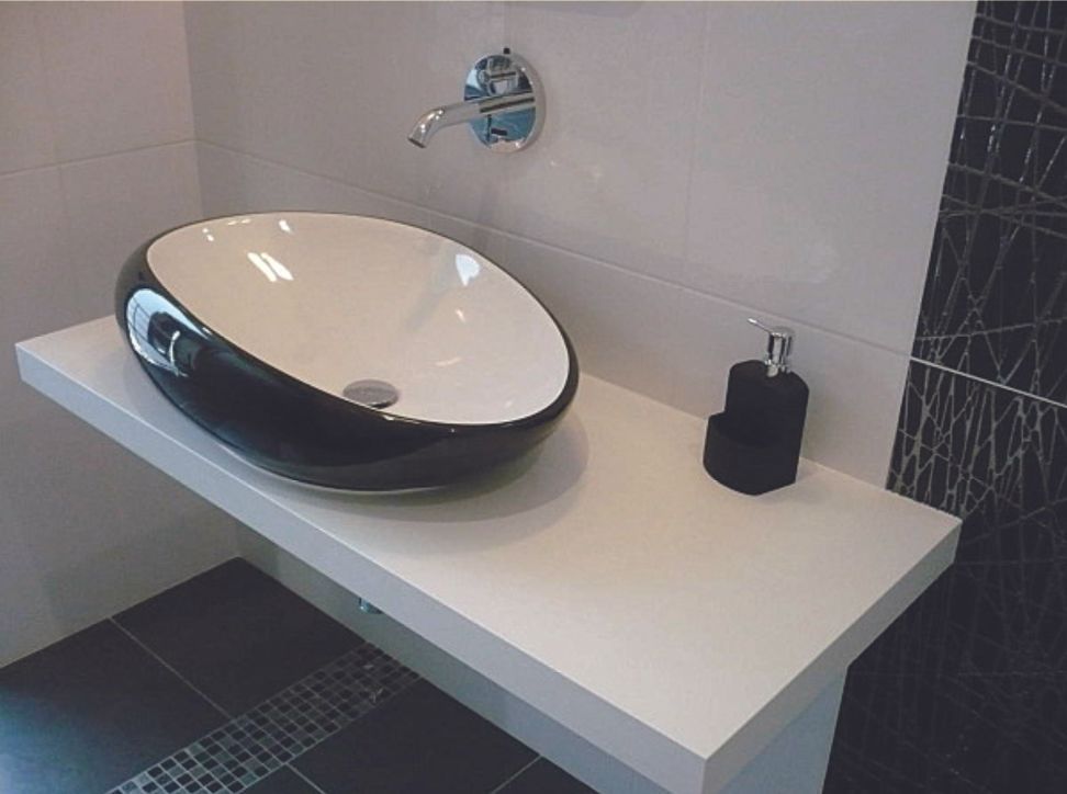 Meuble-lavabo avec vasque noire et blanche, robinet mural et distributeur de savon