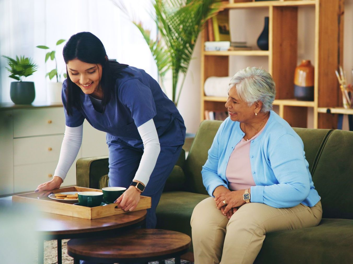 Une infirmière et une patiente âgée avec un plateau de nourriture
