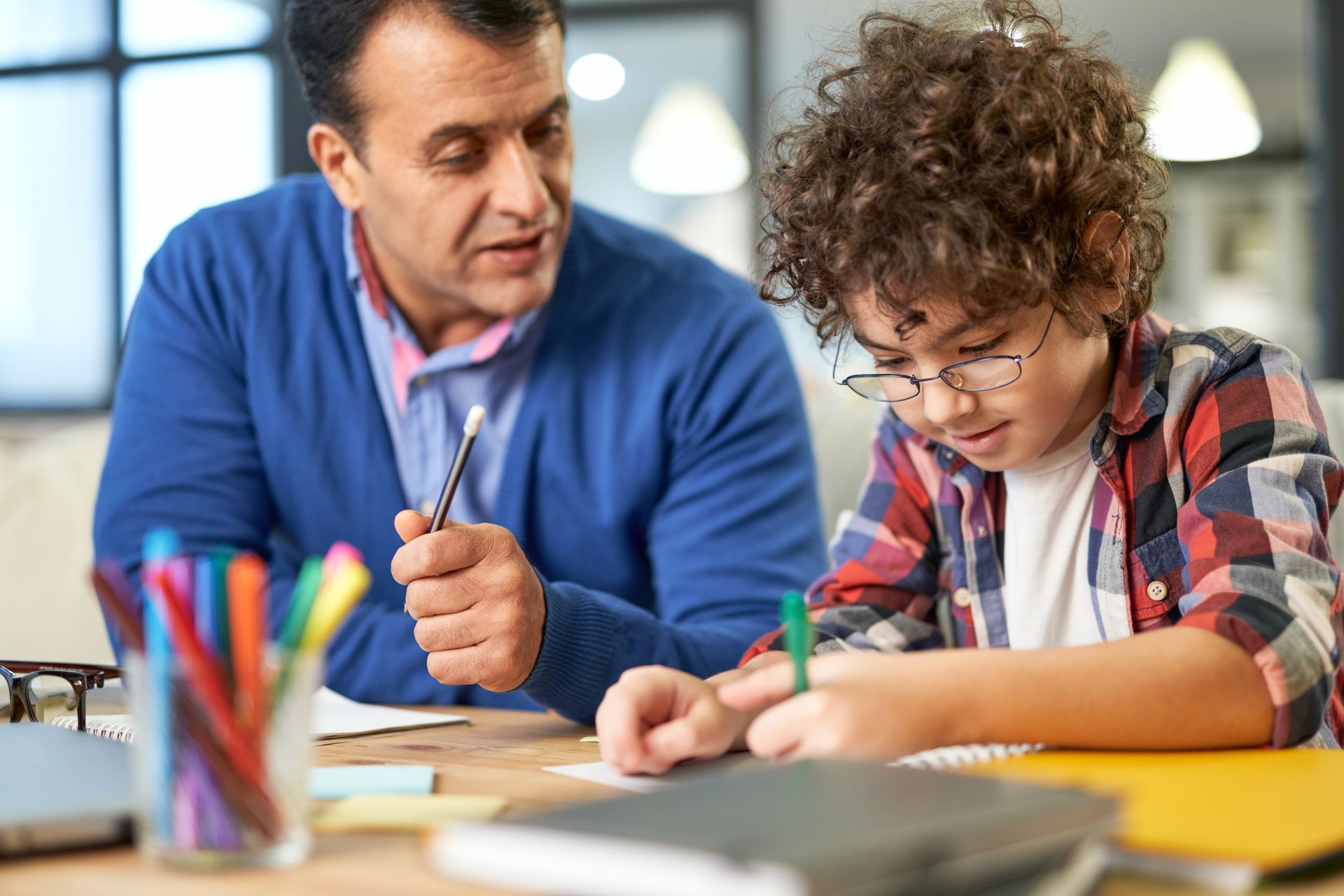 Un homme qui aide un enfant à faire ses devoirs